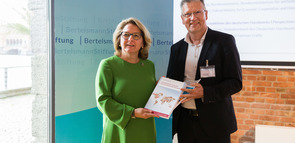 Ulrich Kober von der Bertelsmann Stiftung übergibt die Abschlusspublikation „Fachkräftemigration fair gestalten durch transnationale Skills Partnerships“ an die Bundesministerin für wirtschaftliche Zusammenarbeit und Entwicklung Svenja Schulze