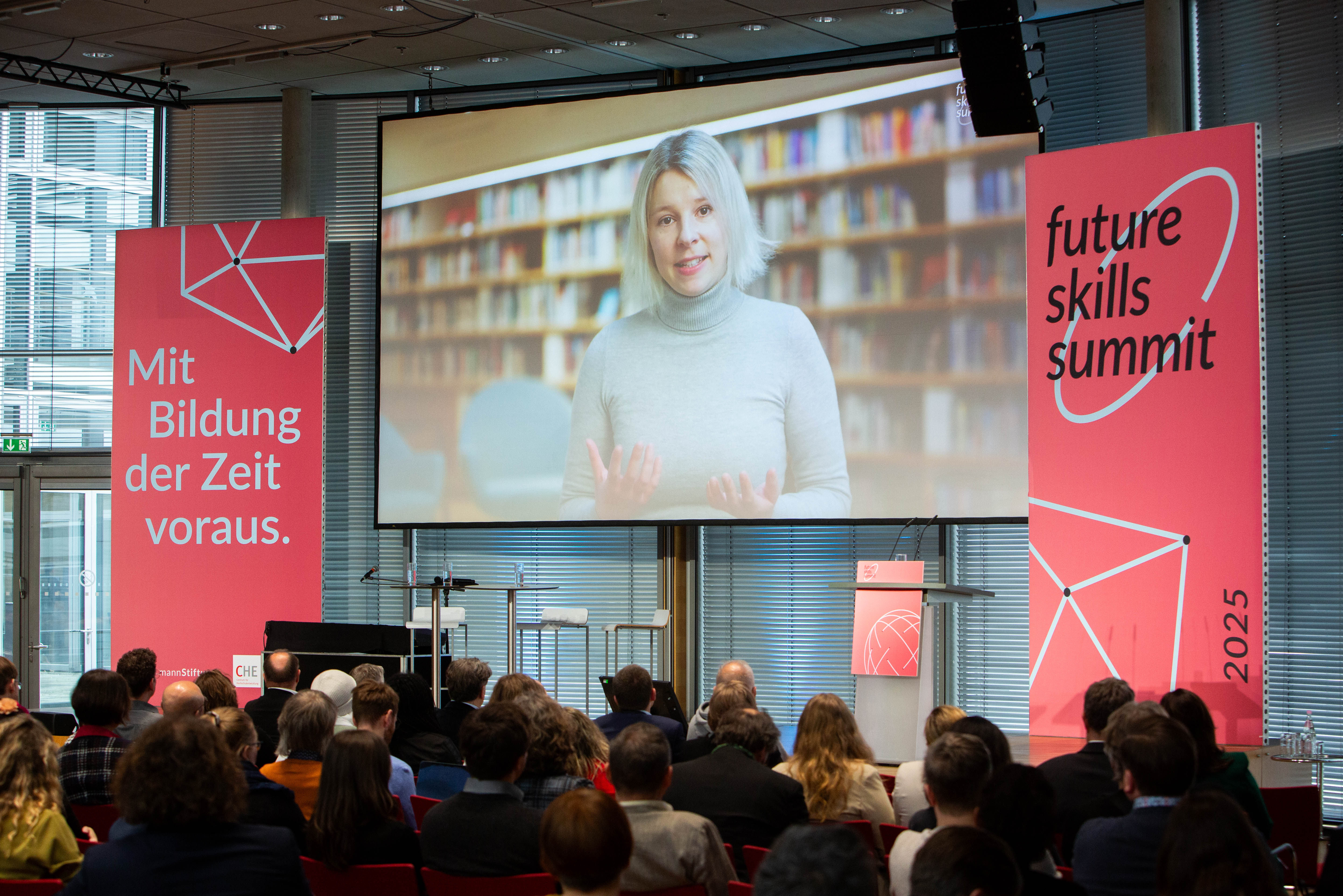(© © Sebastian Pfütze) Ansicht auf die große Leinwand mit Larissa Klemme darauf, Publikum von hinten.